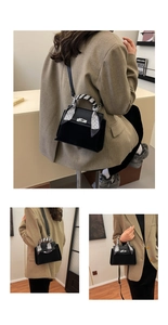 Detail of black suede Kelly bag with silk scarf handle and metal clasp closure