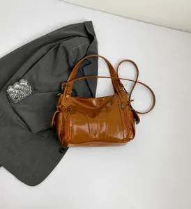 Top view of brown glossy PU tote bag with multiple zipper pockets and detachable strap
