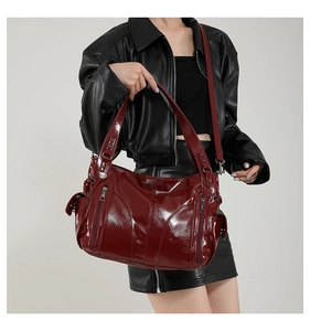 Close-up of burgundy glossy faux leather tote bag with stylish triangular stitching detail