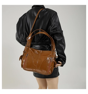 Detailed view of brown glossy PU leather tote bag with vintage texture and zipper accents