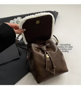Detail of vintage brown drawstring backpack featuring white shearling trim and magnetic closure