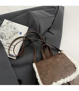 Detail showing vintage brown leather bag with white faux fur trim on grey blazer background