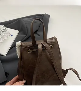 Detail of vintage brown leather backpack with white faux fur trim and drawstrings