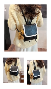 Detail of black faux leather backpack with white faux fur trim and small bear charm