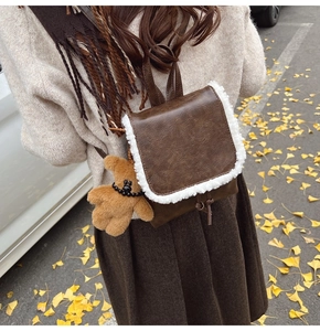 Detail view of retro mini backpack with fleece trim and cute brown plush bear charm