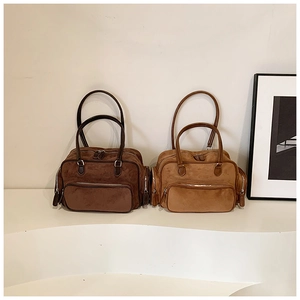 Detail view of vintage suede shoulder bags in dark brown and caramel with multi-pockets