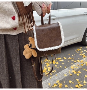 Brown faux leather backpack with white sherpa trim and a cute plush bear charm detail