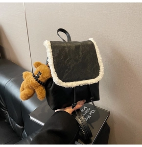 Mini black leather backpack featuring white faux fur trim and a cute plush bear charm