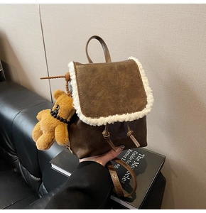 Close-up of brown faux leather mini backpack with plush teddy bear and shearling trim