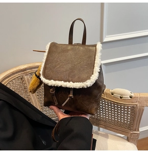 Detail of brown PU leather mini backpack with white faux fur trim and drawstring closure