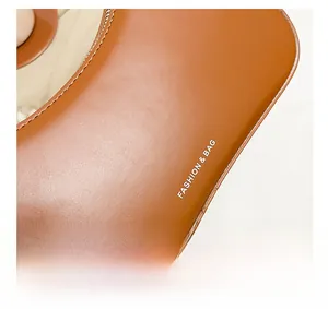 Detail showing smooth brown leather texture with white FASHION & BAG printed lettering