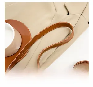 Detail of comfortable brown leather shoulder strap and metallic zipper on underarm bag