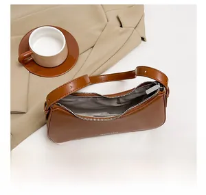 Brown faux leather baguette bag with silver zipper and spacious interior storage