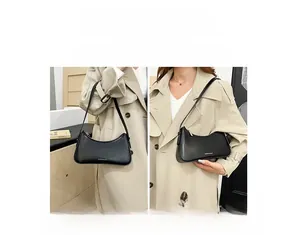 Close-up of minimalist black leather underarm bag shown as handbag and shoulder bag