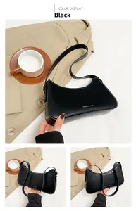 Detail of minimalist black leather crescent bag with white Fashion & Bag lettering