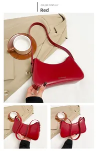 Detail view of a dark red shoulder bag with elegant curves and fashion text engraving