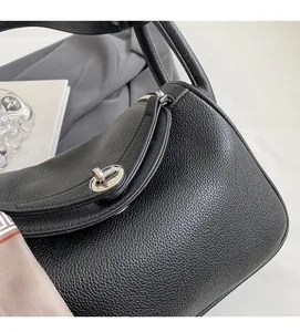 Detail of black pebbled leather texture and silver turn-lock on this stylish Lindy bag