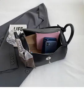Spacious interior of black lychee leather handbag showing tablet and smartphone storage