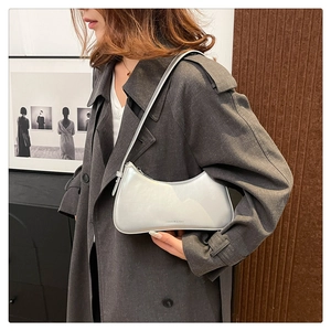 Detail of silver metallic underarm bag with Fashion & Bag text and sleek zipper