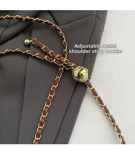 Gros plan de la boucle à bille dorée réglable sur la bandoulière en cuir et chaîne