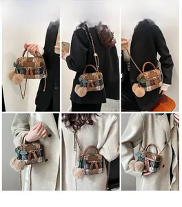 Détail sac seau en tweed avec bandoulière chaîne et pompon sur mannequin
