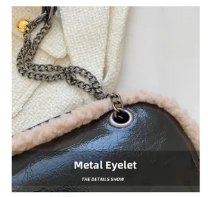 Detail of dark brown leather handbag with cream faux fur trim and silver metal eyelets