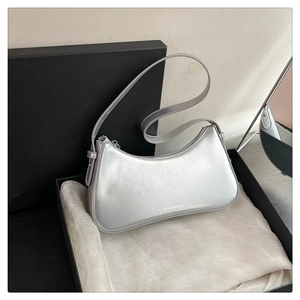 Detailed view of silver metallic crescent bag with smooth zipper and FASHION & BAG logo