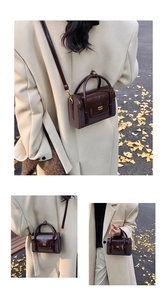 Detail showing vintage brown square bag with glossy wrinkled flap and gold COIN text