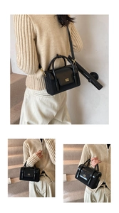 Close-up of black leather handbag featuring golden metal hardware and COIH 2DN logo