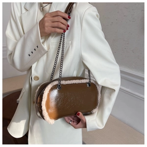 Detailed shot of brown glossy crossbody bag with white faux fur trim and silver chain