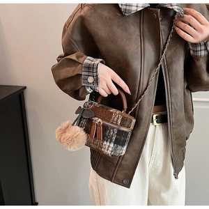 Détail du sac bandoulière en tweed avec pompon en peluche et bandoulière chaîne