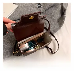 Internal view of dark brown leather crossbody bag showing space for phone and makeup