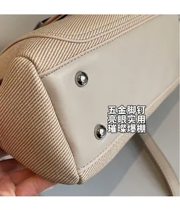 Detail of the bucket bag base with silver metal feet and durable twill fabric texture