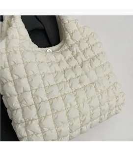 Close-up of quilted polyester fabric texture and metal magnetic closure on tote bag