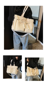 Detailed view of beige nylon multi-pocket tote bag with adjustable shoulder straps