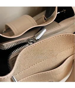 Macro detail of high-quality polished silver metal zipper on khaki bucket bag