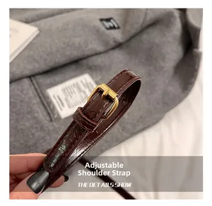 Detail of adjustable dark brown patent leather strap with gold metal buckle