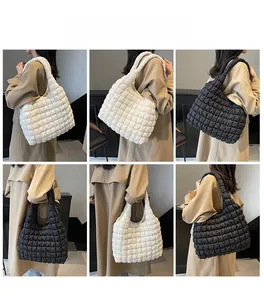 Quilted puffer tote bag in black and white styles worn with a beige trench coat