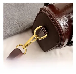 Close-up of golden metal lobster clasp and premium dark brown leather strap detail