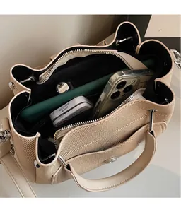 Interior view of beige bucket bag showing spacious compartments and zipper pocket