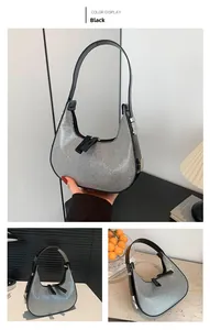 Detail of silver rhinestone crescent bag with black leather strap and star zipper pull