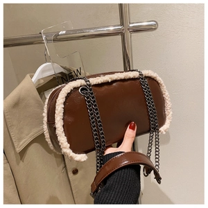 Close-up of brown patent leather crossbody bag with beige faux fur trim and chain strap