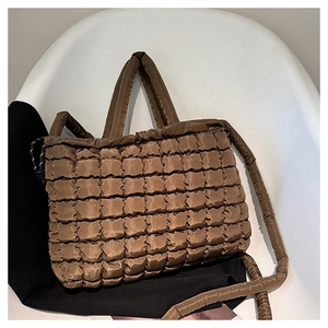 Gros plan du sac cabas matelassé marron avec texture rembourrée et coutures carrées