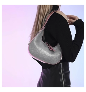 Detailed view of silver sequin hobo bag with pink leather trim worn by a model