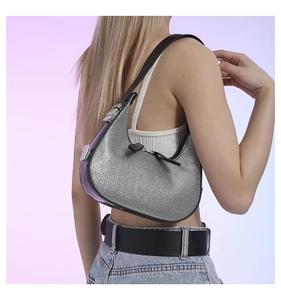 Detail of sparkly silver sequin hobo bag with black shoulder strap worn by a model