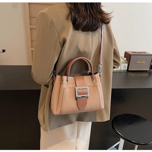 Detail of minimalist apricot bucket bag with silver metal buckle and adjustable strap