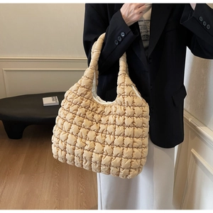 Detail of the beige quilted tote bag showing its fluffy texture and grid pattern