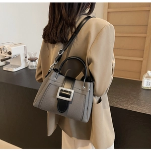 Detail view of grey and black canvas bucket bag with adjustable leather strap