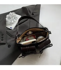 Detailansicht der dunkelbraunen Lackleder-Handtasche mit Schleifen und viel Platz