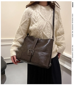 Detail of dark brown vintage faux leather bag featuring a large antique silver buckle clasp